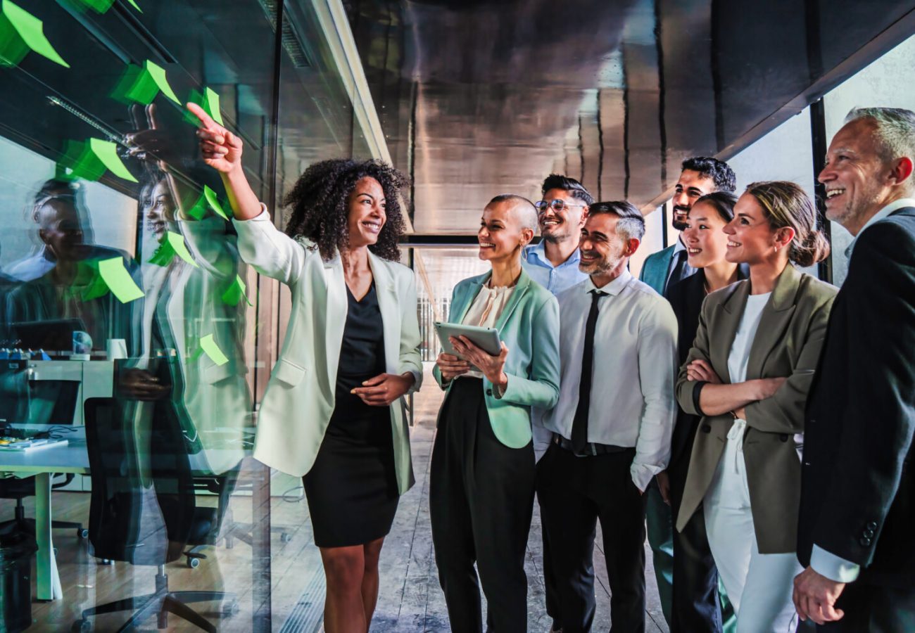 Group of business people start up team work brainstorming using post it in the office on a happy collaboration meeting. Businesswoman explaining the new marketing strategy or plan to her coworkers. High quality photo